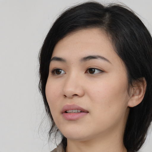 Joyful asian young-adult female with medium  black hair and brown eyes