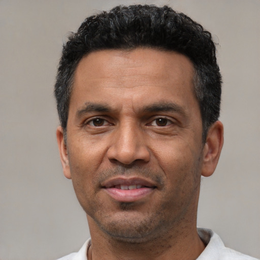 Joyful latino adult male with short  black hair and brown eyes