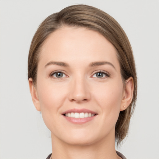 Joyful white young-adult female with medium  brown hair and grey eyes