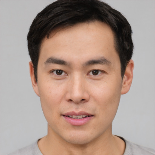 Joyful asian young-adult male with short  black hair and brown eyes