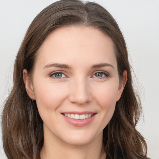 Joyful white young-adult female with long  brown hair and grey eyes