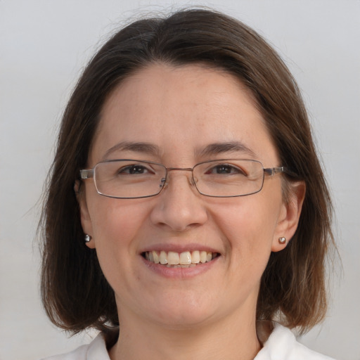 Joyful white adult female with medium  brown hair and blue eyes