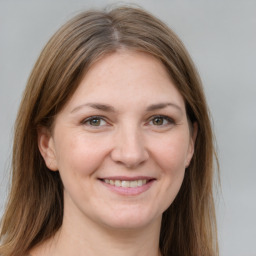 Joyful white young-adult female with long  brown hair and grey eyes