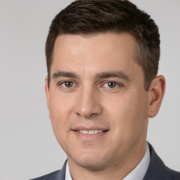 Joyful white young-adult male with short  brown hair and brown eyes