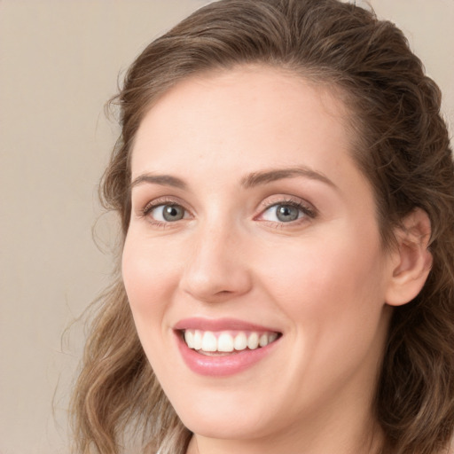 Joyful white young-adult female with long  brown hair and green eyes