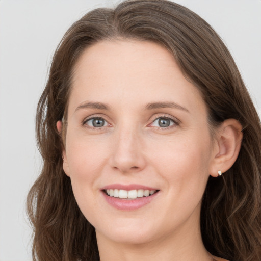 Joyful white young-adult female with long  brown hair and grey eyes