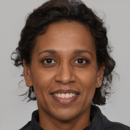 Joyful black adult female with medium  brown hair and brown eyes