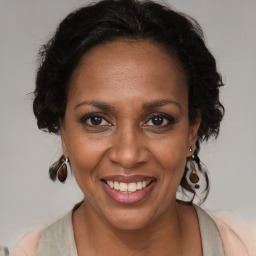 Joyful black adult female with medium  brown hair and brown eyes