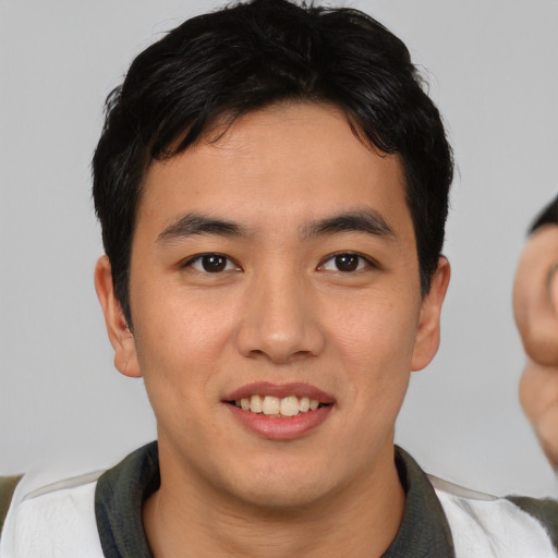 Joyful asian young-adult male with short  black hair and brown eyes