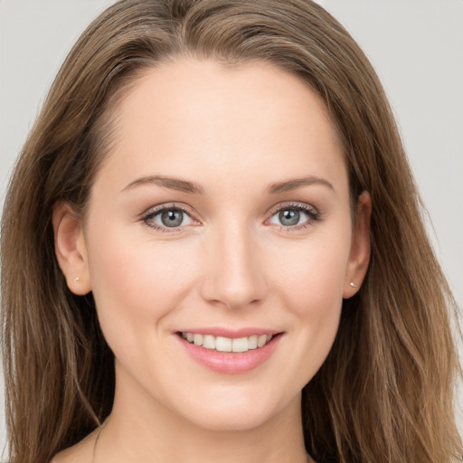 Joyful white young-adult female with long  brown hair and grey eyes