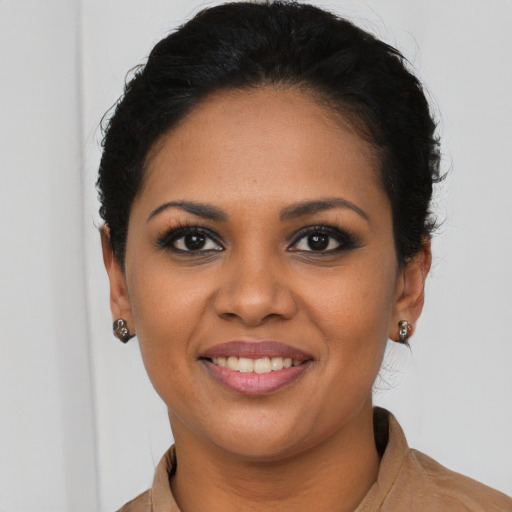 Joyful latino young-adult female with short  black hair and brown eyes