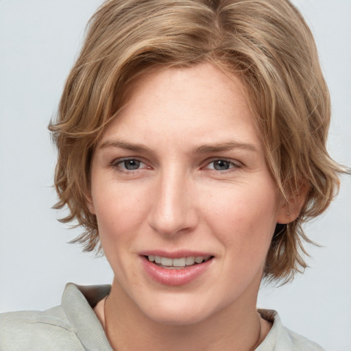 Joyful white young-adult female with medium  brown hair and blue eyes