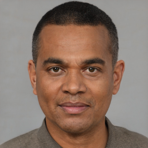 Joyful black adult male with short  black hair and brown eyes