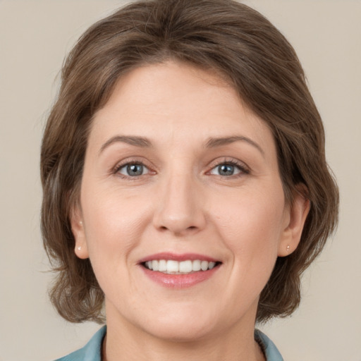 Joyful white adult female with medium  brown hair and brown eyes