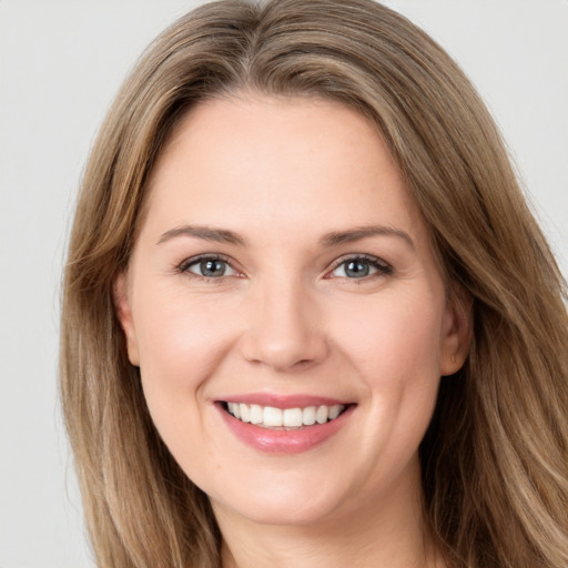 Joyful white young-adult female with long  brown hair and green eyes