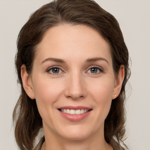 Joyful white young-adult female with medium  brown hair and grey eyes