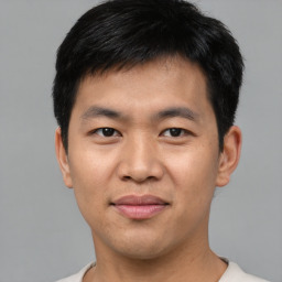 Joyful asian young-adult male with short  black hair and brown eyes