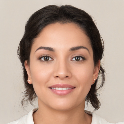 Joyful latino young-adult female with medium  brown hair and brown eyes