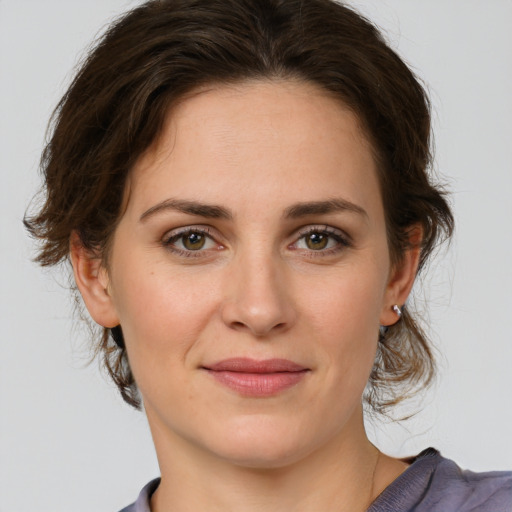 Joyful white young-adult female with medium  brown hair and green eyes