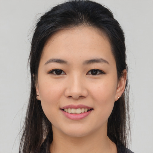 Joyful asian young-adult female with long  brown hair and brown eyes