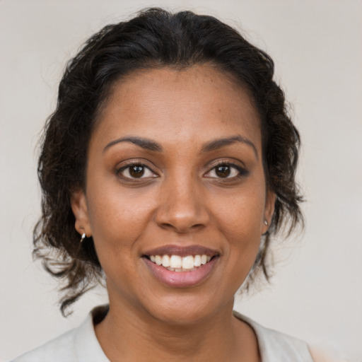 Joyful black young-adult female with medium  brown hair and brown eyes