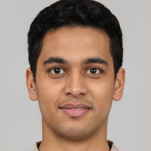 Joyful latino young-adult male with short  black hair and brown eyes