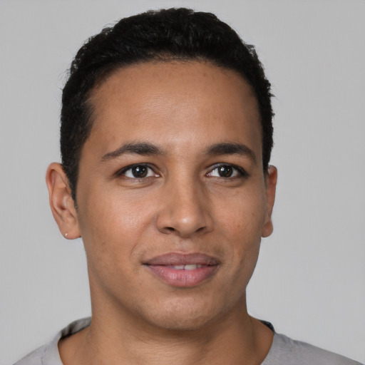 Joyful latino young-adult male with short  black hair and brown eyes