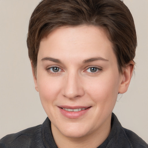 Joyful white young-adult female with short  brown hair and grey eyes