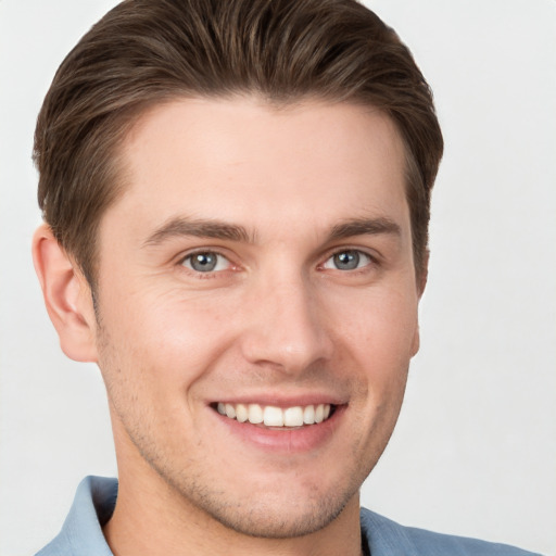 Joyful white young-adult male with short  brown hair and grey eyes