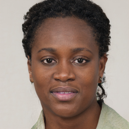 Joyful black young-adult female with short  brown hair and brown eyes