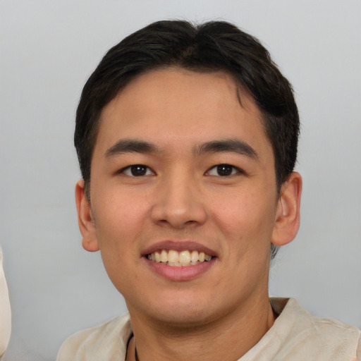 Joyful asian young-adult male with short  brown hair and brown eyes