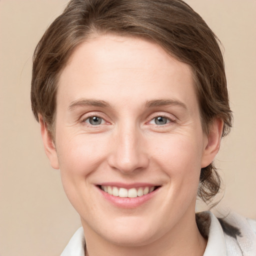 Joyful white young-adult female with medium  brown hair and green eyes