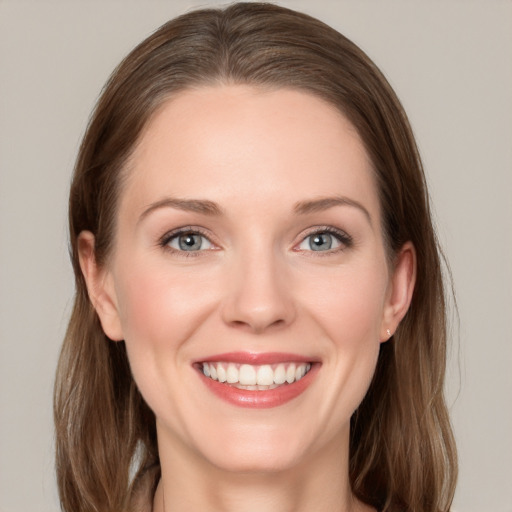 Joyful white young-adult female with long  brown hair and blue eyes