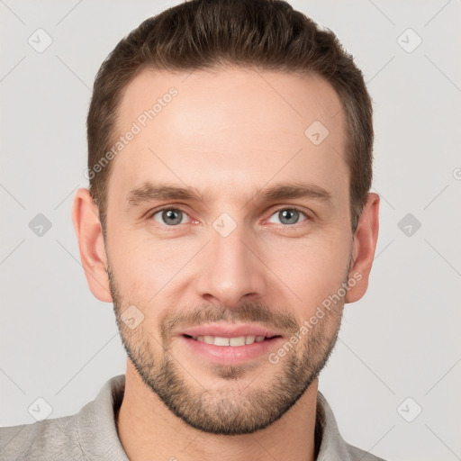 Joyful white young-adult male with short  brown hair and grey eyes