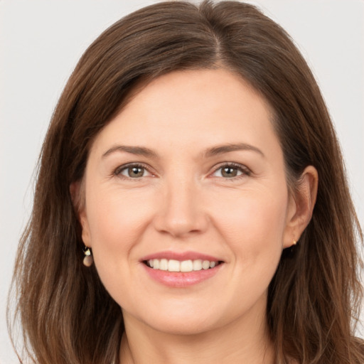 Joyful white young-adult female with long  brown hair and brown eyes