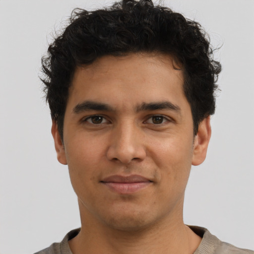 Joyful latino young-adult male with short  brown hair and brown eyes
