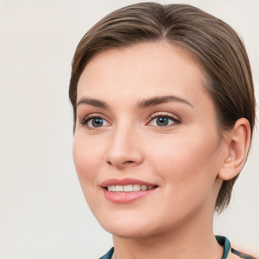 Joyful white young-adult female with short  brown hair and blue eyes