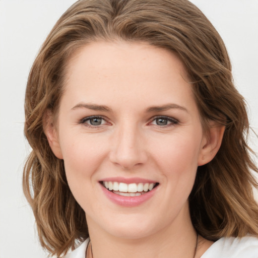 Joyful white young-adult female with medium  brown hair and blue eyes