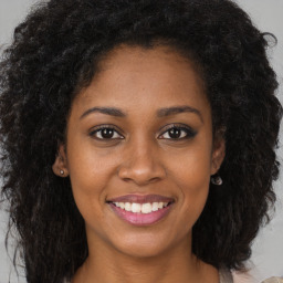 Joyful black young-adult female with long  brown hair and brown eyes