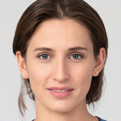 Joyful white young-adult female with medium  brown hair and grey eyes