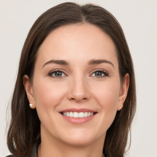 Joyful white young-adult female with long  brown hair and grey eyes