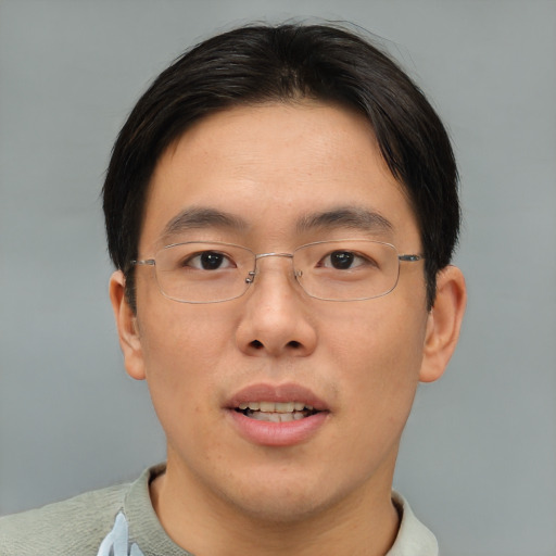 Joyful asian adult male with short  brown hair and brown eyes