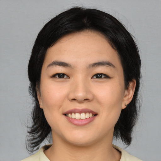 Joyful asian young-adult female with medium  black hair and brown eyes