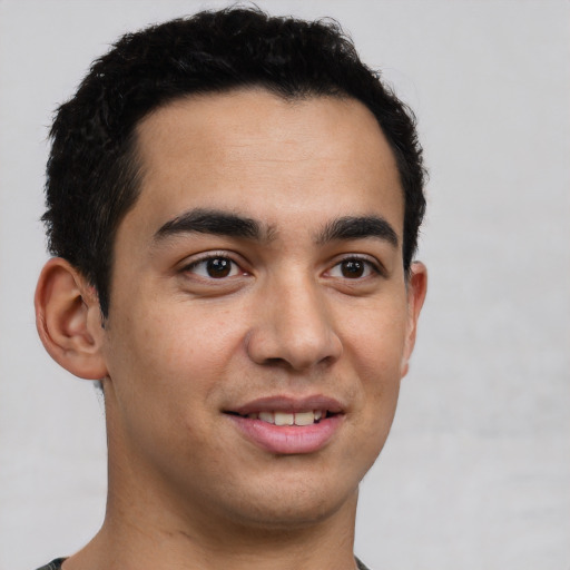 Joyful latino young-adult male with short  brown hair and brown eyes