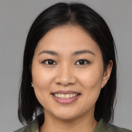 Joyful asian young-adult female with medium  brown hair and brown eyes
