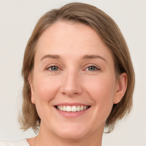 Joyful white young-adult female with medium  brown hair and green eyes