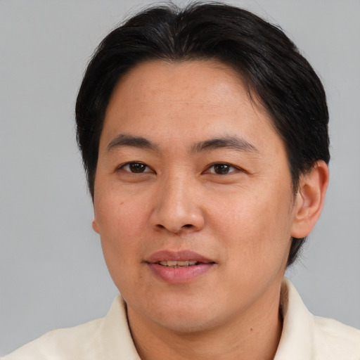 Joyful asian adult male with short  brown hair and brown eyes
