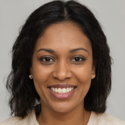 Joyful black young-adult female with medium  brown hair and brown eyes