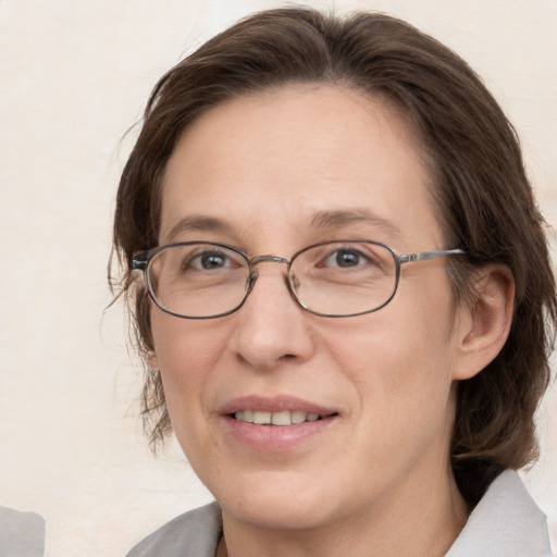 Joyful white adult female with medium  brown hair and grey eyes