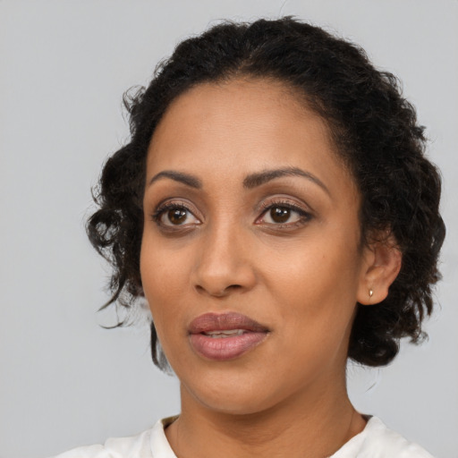 Joyful latino adult female with medium  black hair and brown eyes